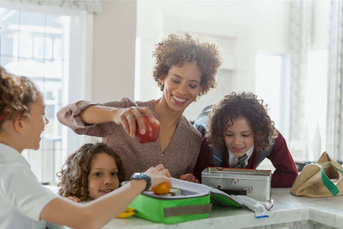 Mom packing lunch with her two daughters.